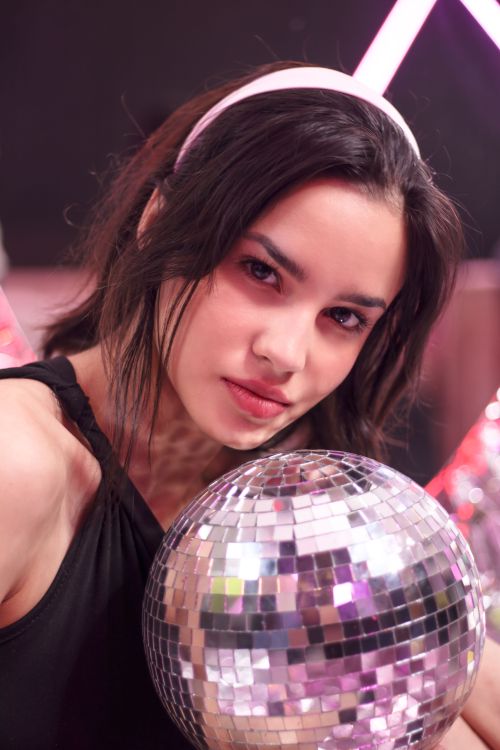 Free Stylish woman holding a disco ball in a vibrant setting in Mexico City. Stock Photo