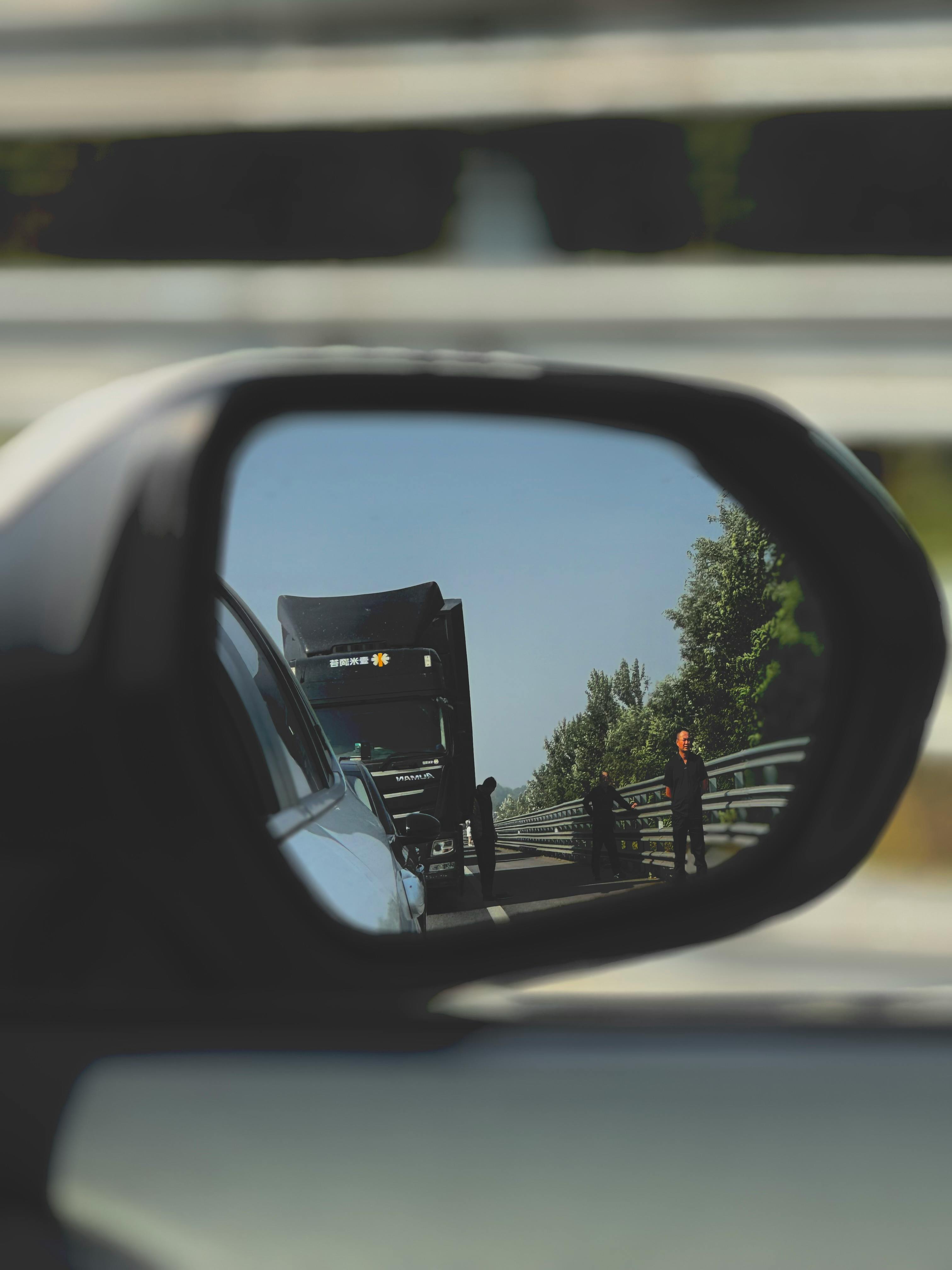 rearview mirror reflection of roadside scene