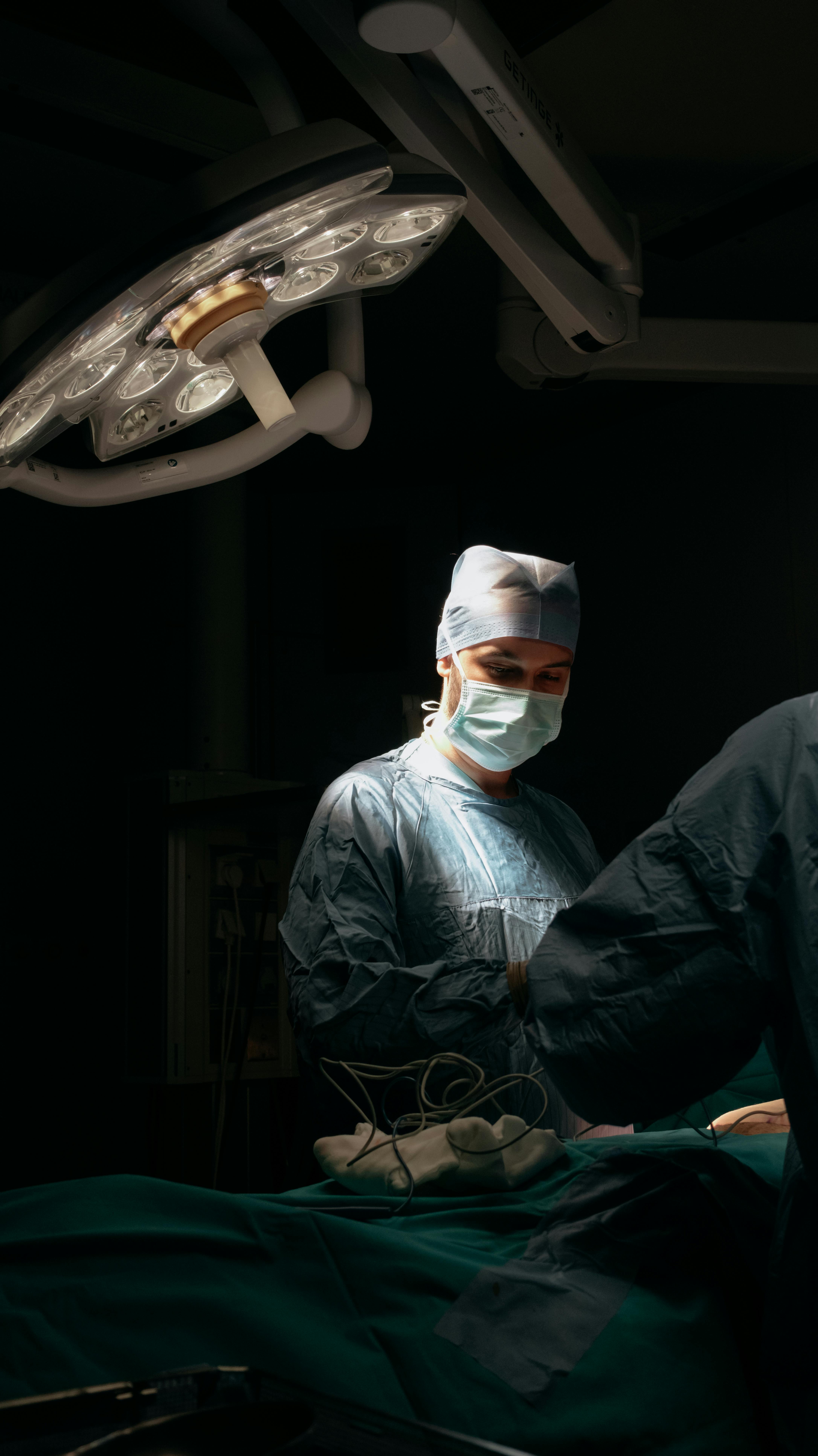 surgeons operating in dimly lit surgical room