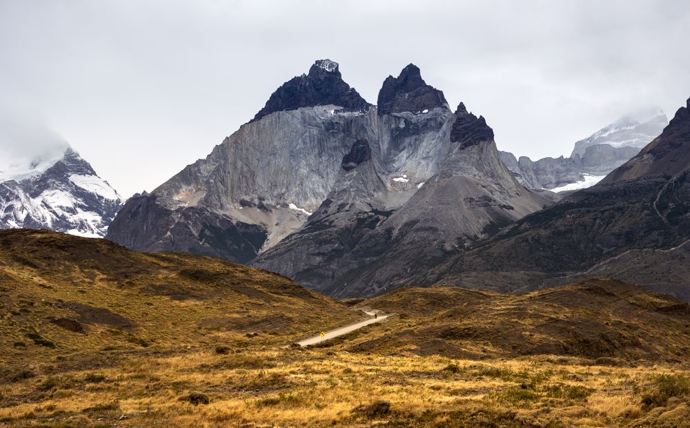 Vista panorámica del macizo del Paine con caminante solitario en la pampa
