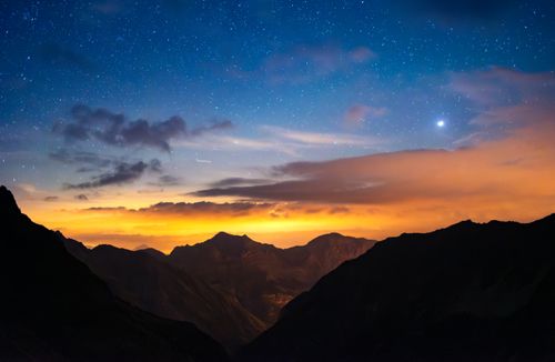 Free Astrophotography capturing the starry night sky over the majestic mountains of Écrins National Park, France. Stock Photo