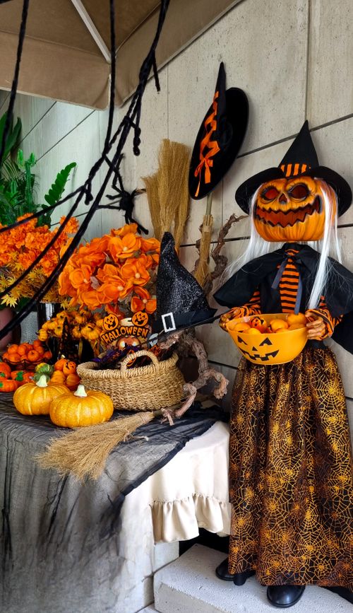 Free Vibrant Halloween decoration featuring a pumpkin witch amidst colorful ornaments. Stock Photo