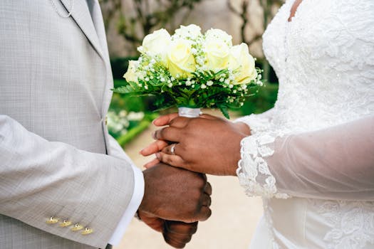 Close-up of wedding couple holding hands with a bouquet. Symbolizes love and commitment.