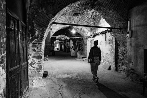 Free A lone woman walking through historic arches in Istanbul's underground passage. Stock Photo