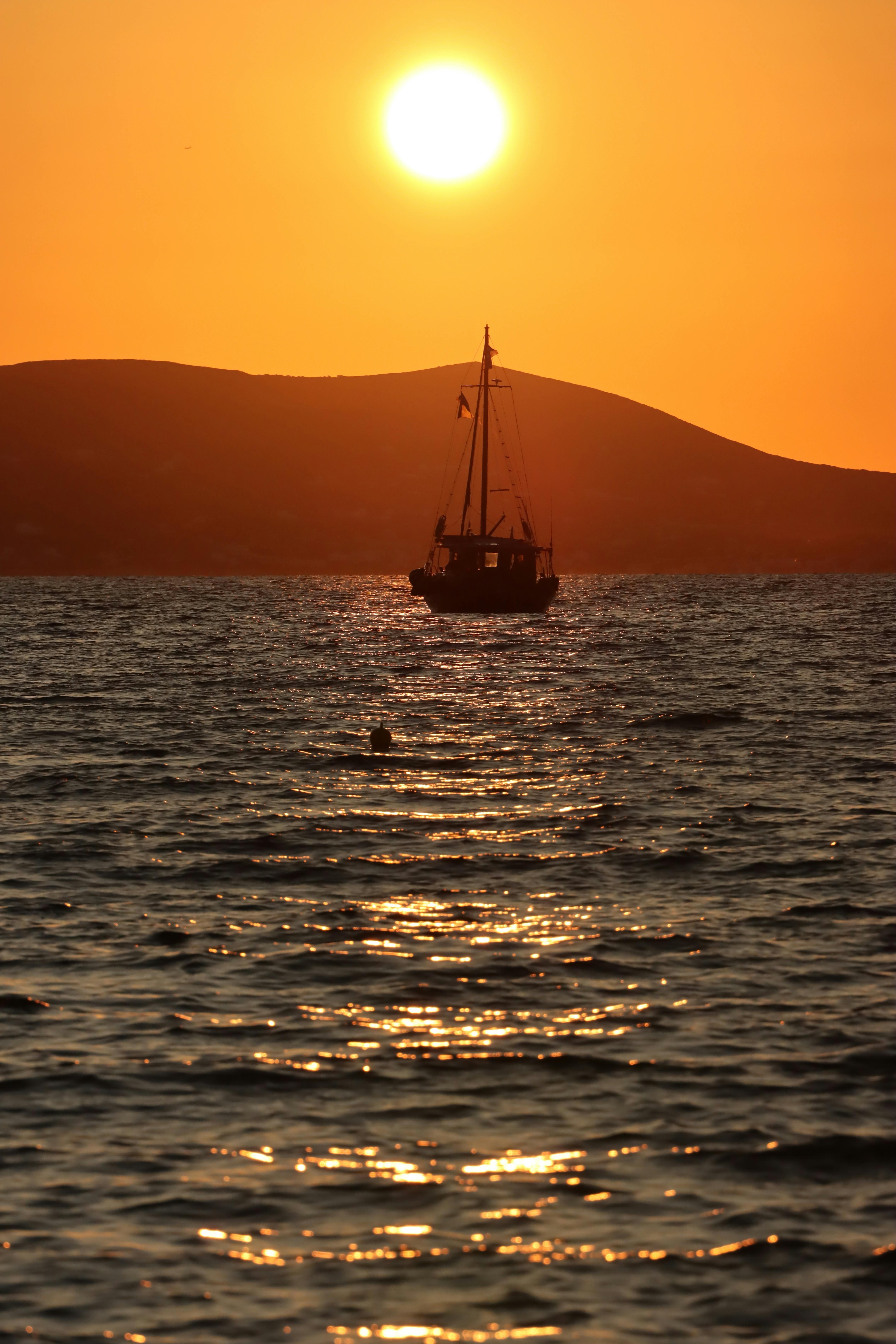 sunset silhouette of a boat in naxos greece