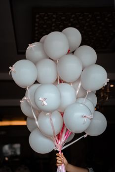 A bunch of white balloons tied with pink ribbons, perfect for celebrations.