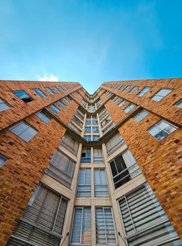 Low-angle view of a modern building against a clear blue sky, showcasing urban architecture.