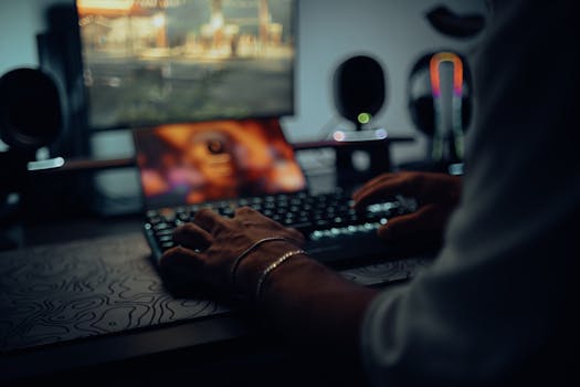 Focused man typing in a dimly lit room, creating a moody atmosphere.