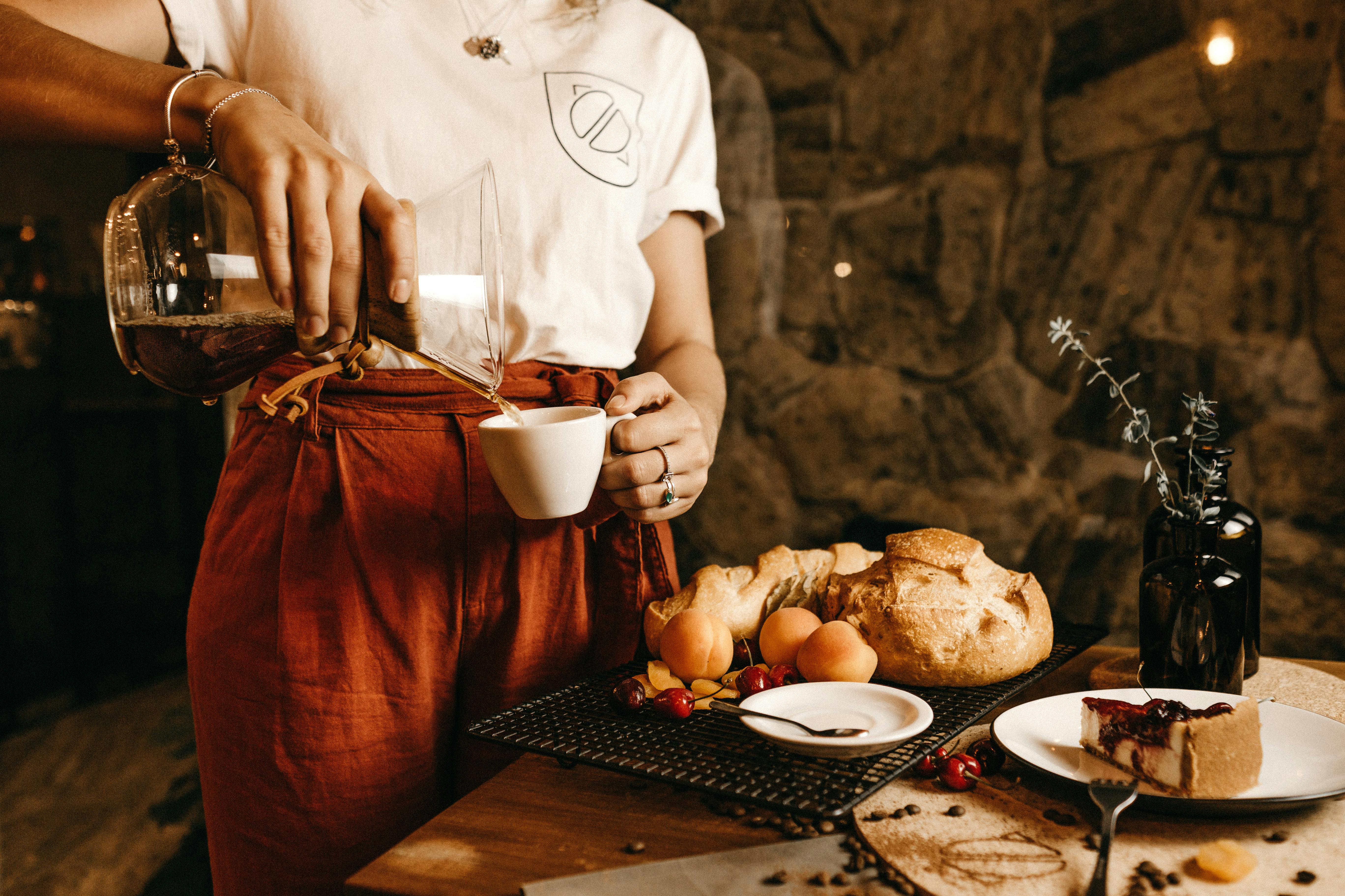 Photo of a waitress pouring a drink into a cup. | Photo: Pexels