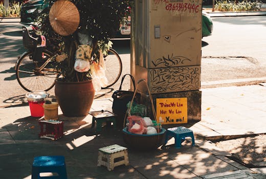 A small street vendor area with stools and goods, captured in autumn light in Hanoi.