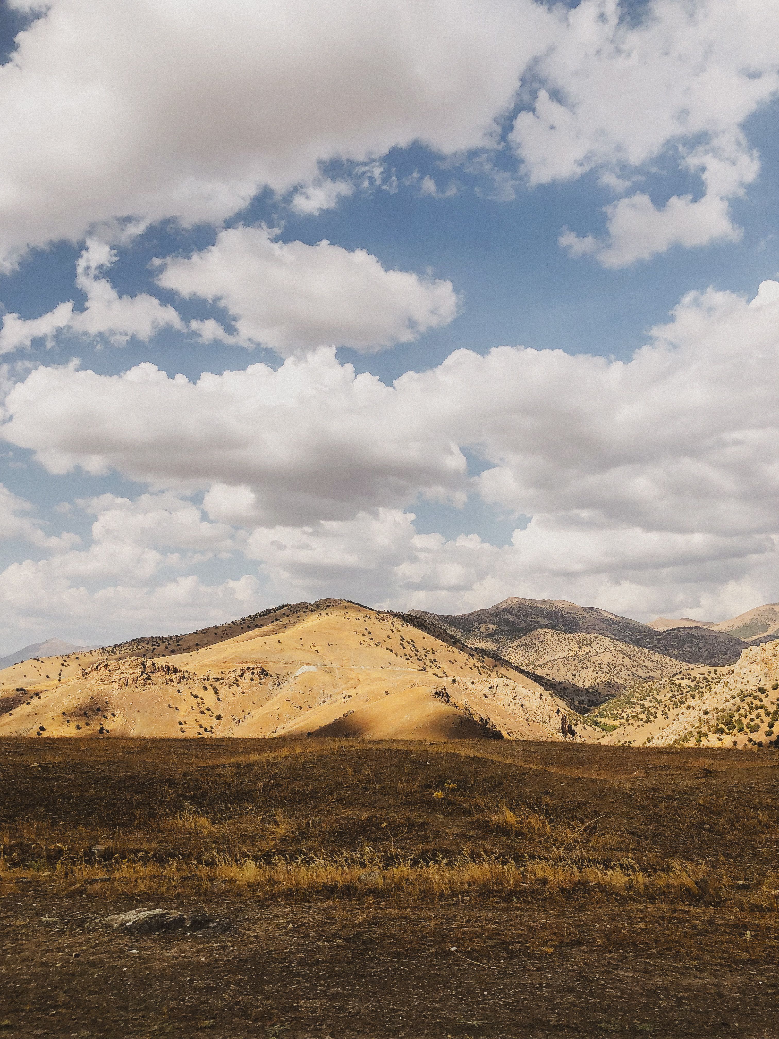 Beautiful Rolling Hills Under a Cloudy Sky · Free Stock Photo