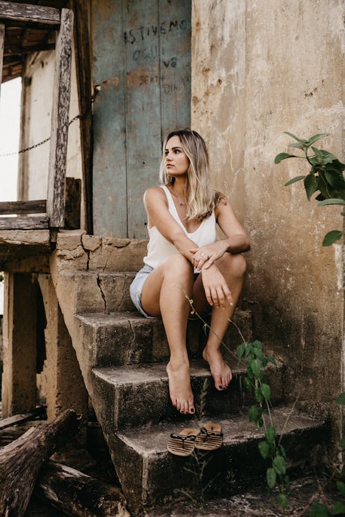Woman in White Tank Top Sitting on Gray Concrete Stair