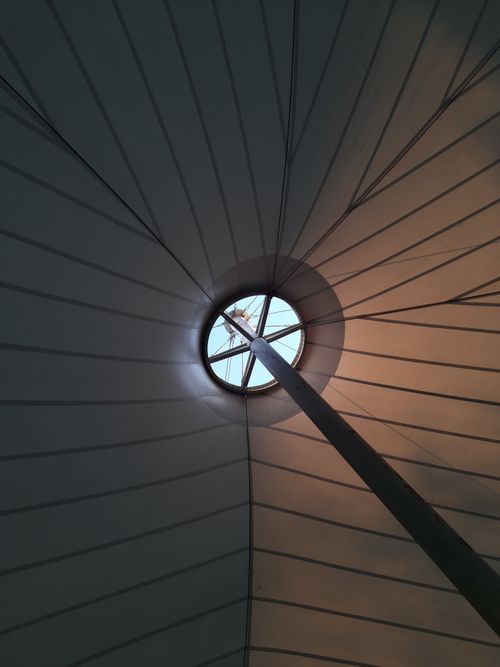 Free View of a circular abstract ceiling with sunlight coming through, creating dynamic shadows. Stock Photo