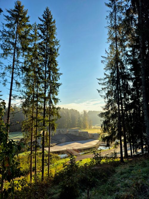 Free Beautiful sunrise view of an outdoor amphitheater surrounded by tall trees and forest. Stock Photo