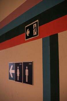 Colorful wall featuring restroom and exit signs in Belo Horizonte, Brazil.