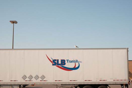 SLB Transit truck under clear sky with bird on roof in Montreal.