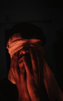 Dramatic low-light portrait of a blindfolded person, emphasizing mystery and emotions.