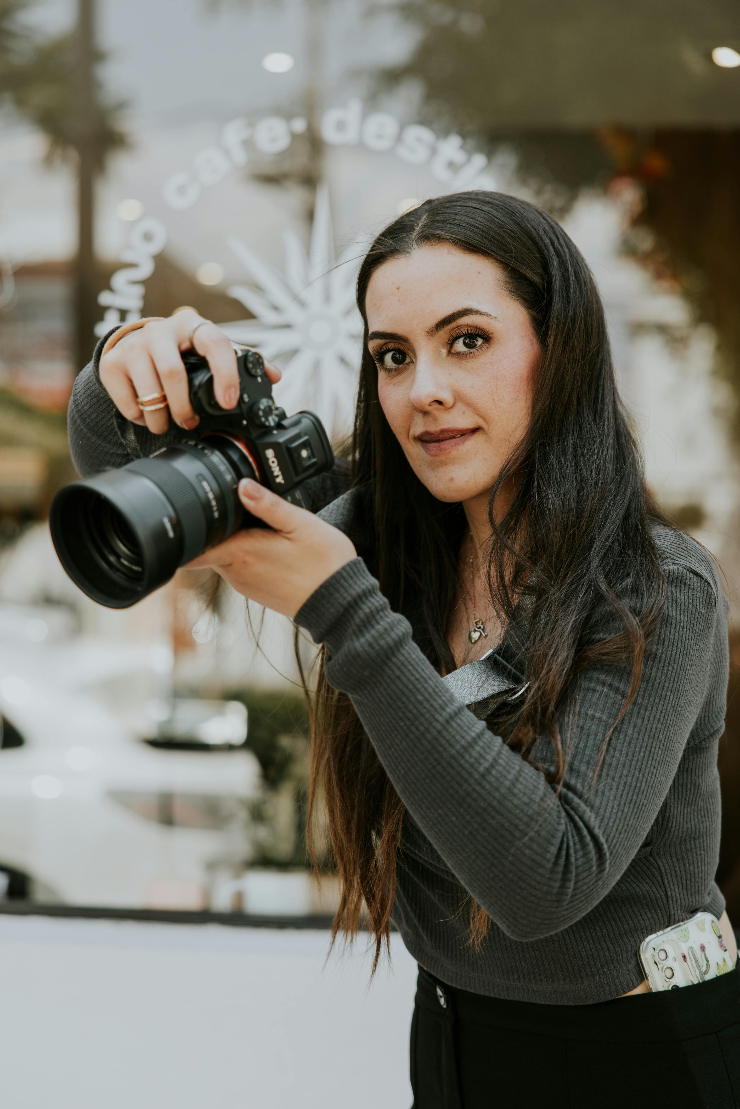 Portrait of a woman photographer capturing moments in a stylish urban cafe.