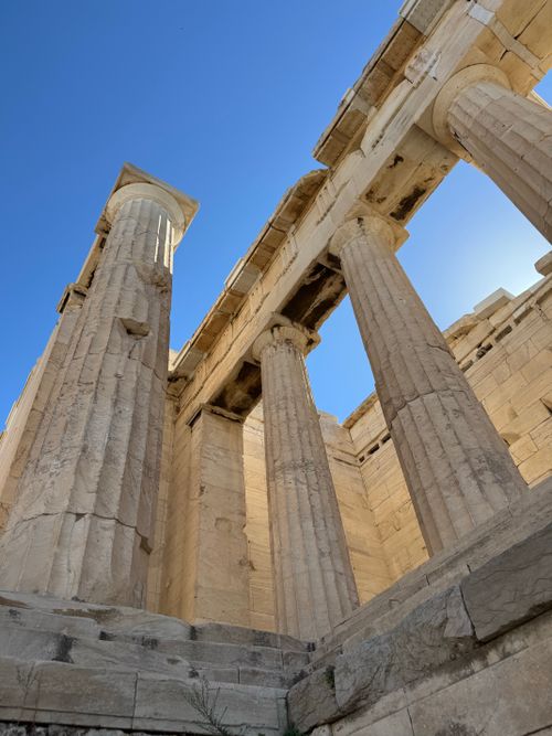 Free Upward view of ancient Greek columns against a clear blue sky, showcasing classical architecture. Stock Photo