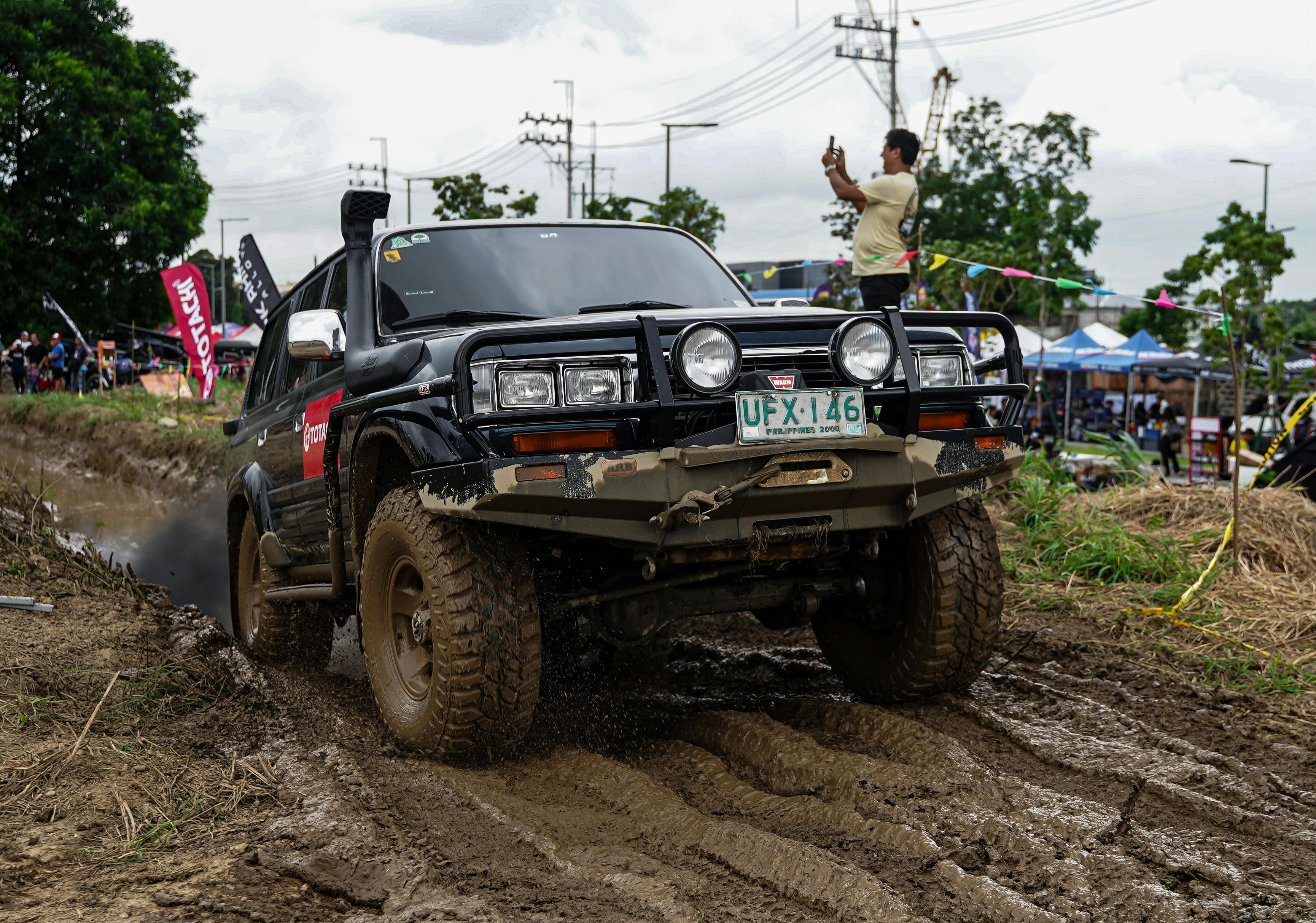 A rugged vehicle navigates a muddy off-road trail in Pasig, showing adrenaline-pumping adventure.