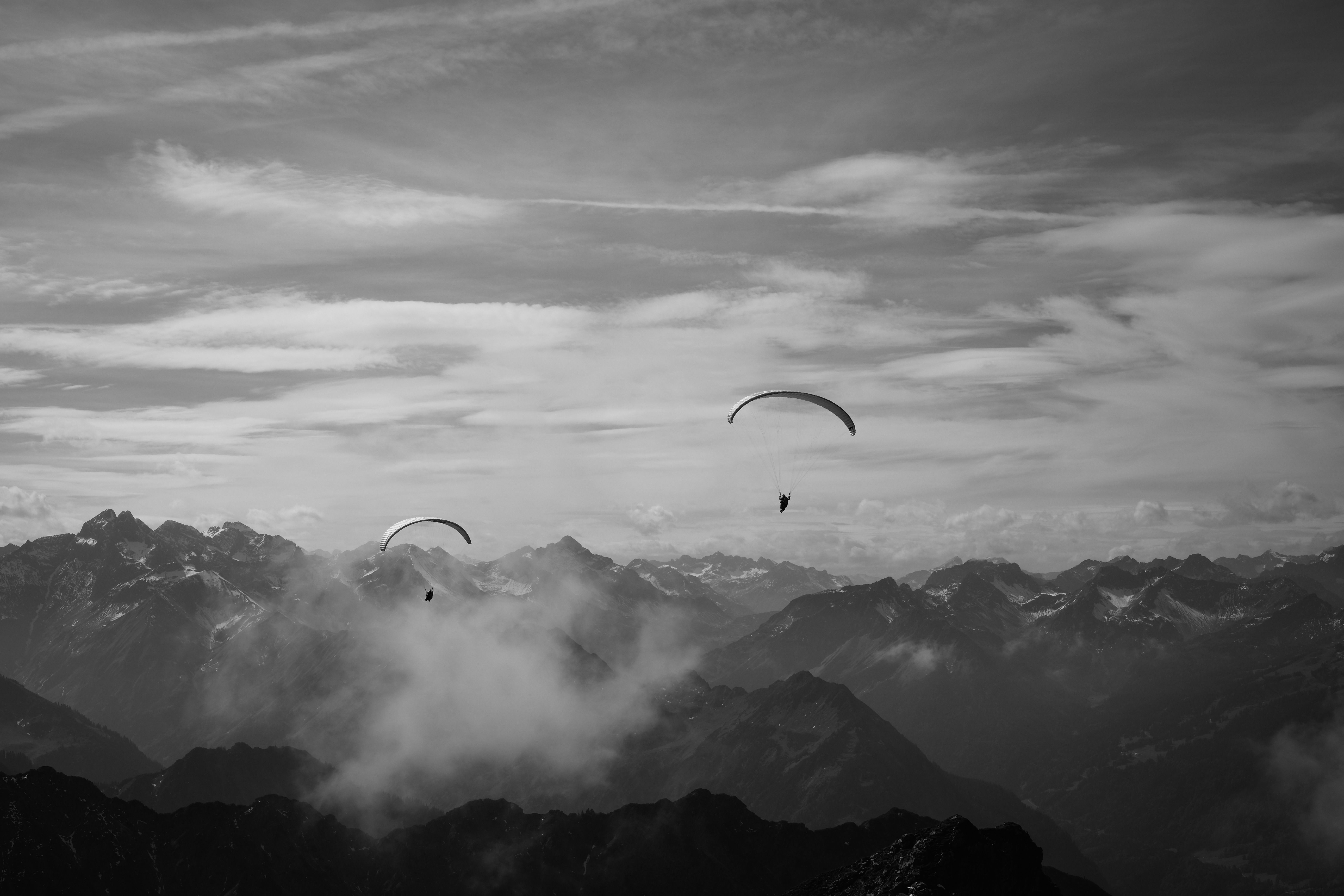 Paragliders Soaring Above Dramatic Mountain Range · Free Stock Photo