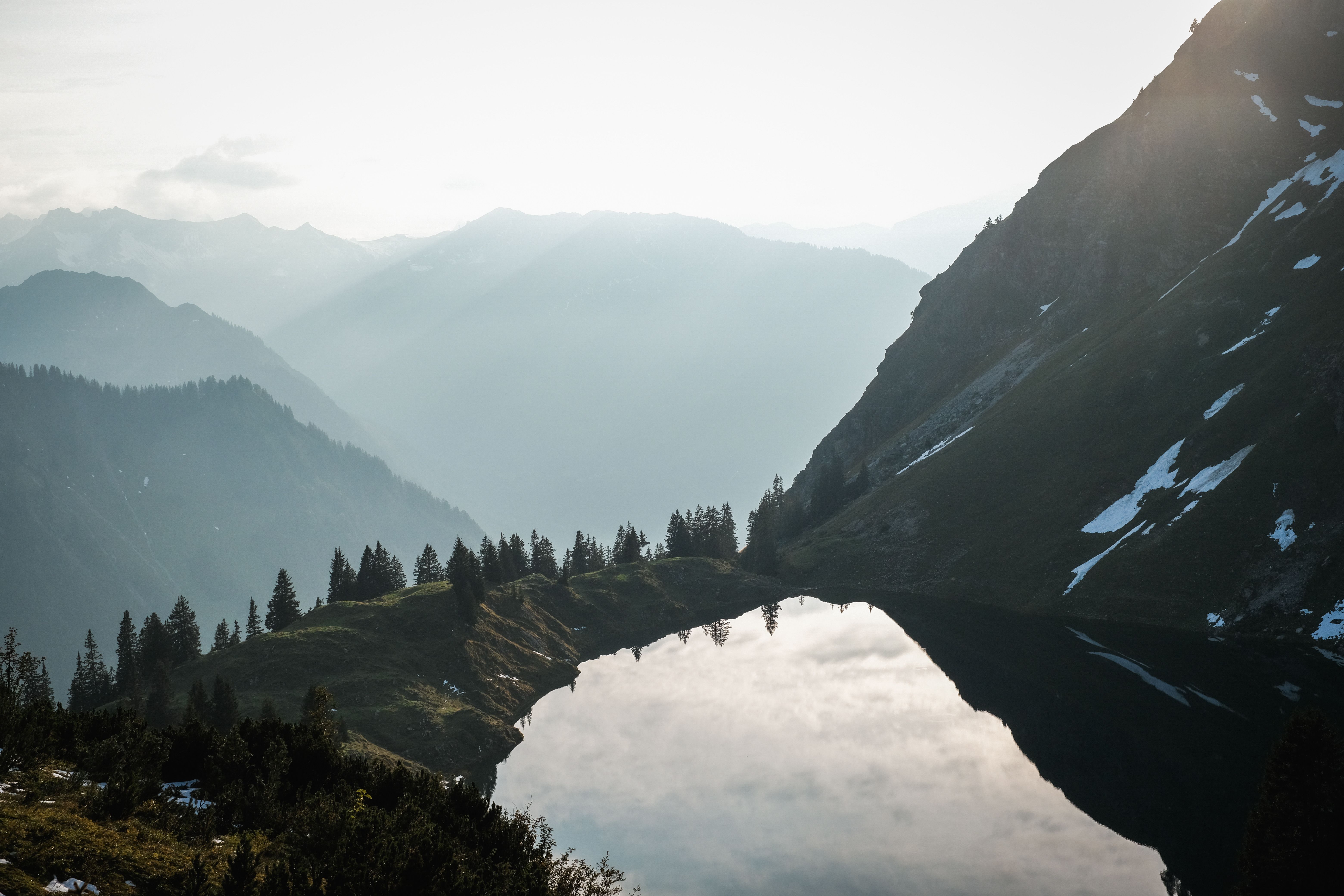 Radiant morning sunlight reflecting over still water and mountains