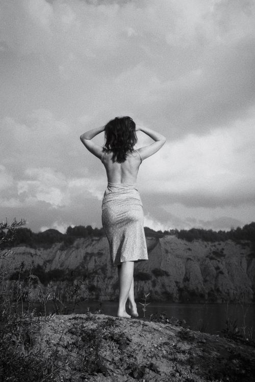 Free Artistic black and white photo of woman standing on a hill. Stock Photo