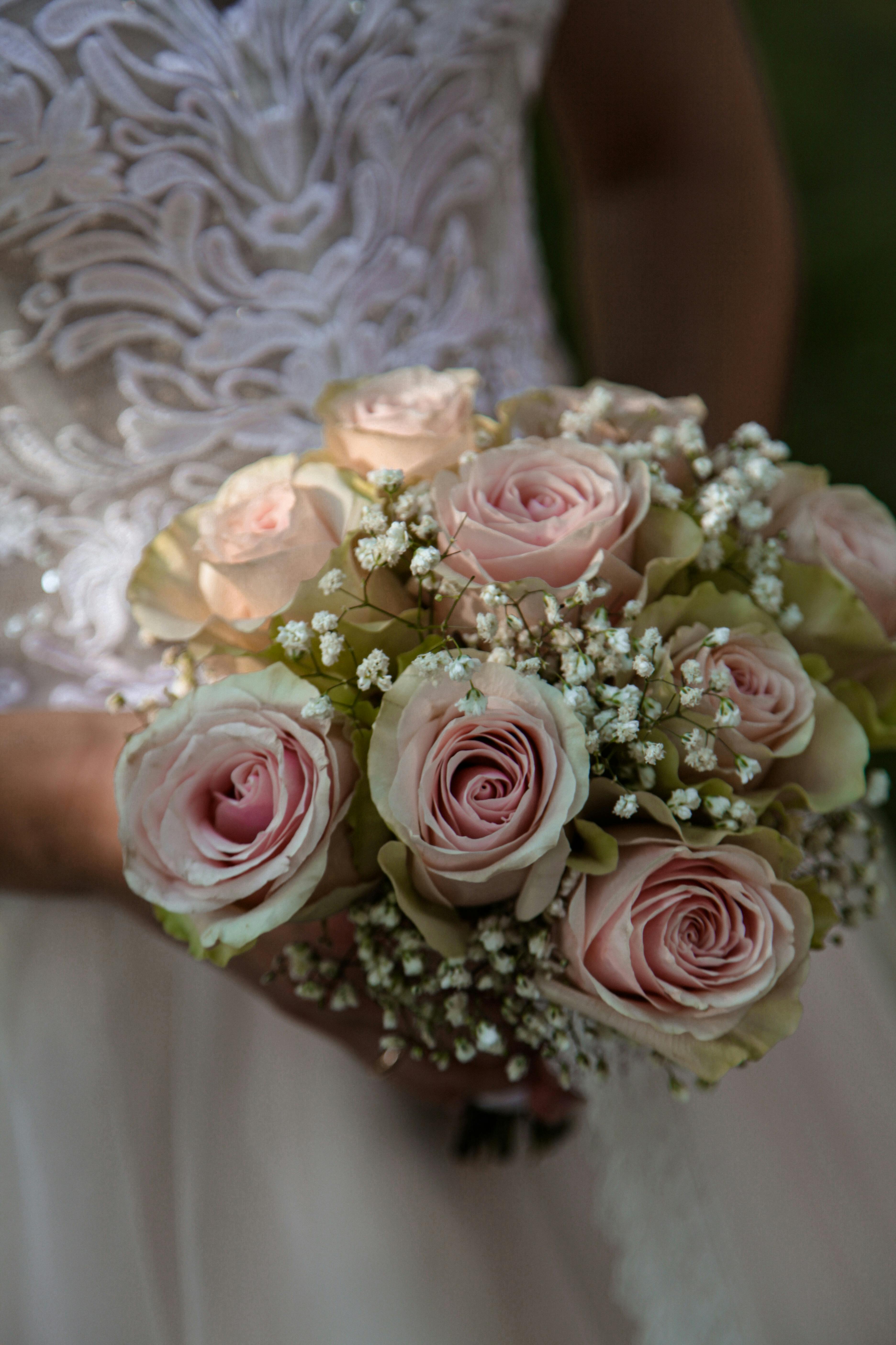 A close-up of a bridal bouquet featuring pink roses and delicate baby's breath.