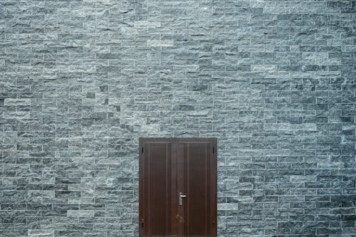무료 평평한 벽돌 벽에 갈색 나무로되는 문 스톡 사진