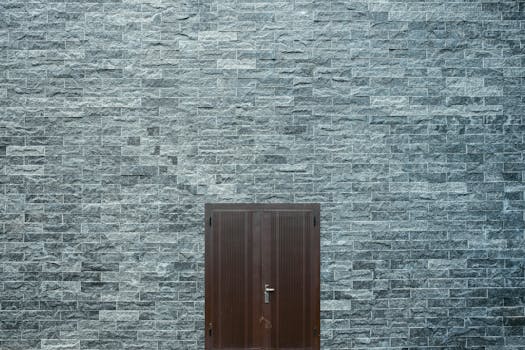 一堵简约的石砖墙上，设有一扇简单的木门，展现了建筑设计