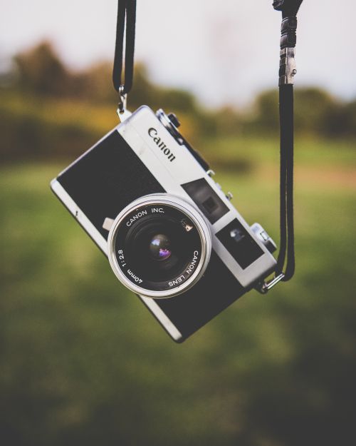 Free Classic film camera suspended outdoors, capturing retro vibes. Stock Photo