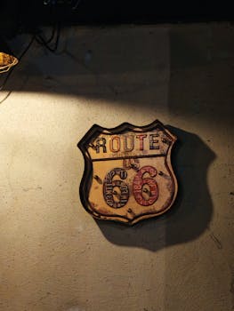 A classic Route 66 sign mounted on a textured wall under warm lighting.