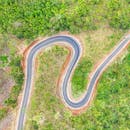 壮丽的鸟瞰图展现了印度尼西亚西爪哇蜿蜒道路在郁郁葱葱的绿色植物中穿行的景象