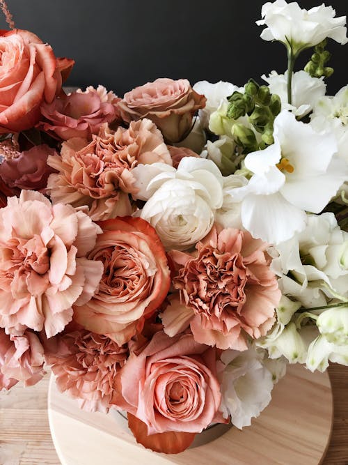 Free High angle of delicate bunch of fresh pink and white floribunda flowers on wooden floor Stock Photo