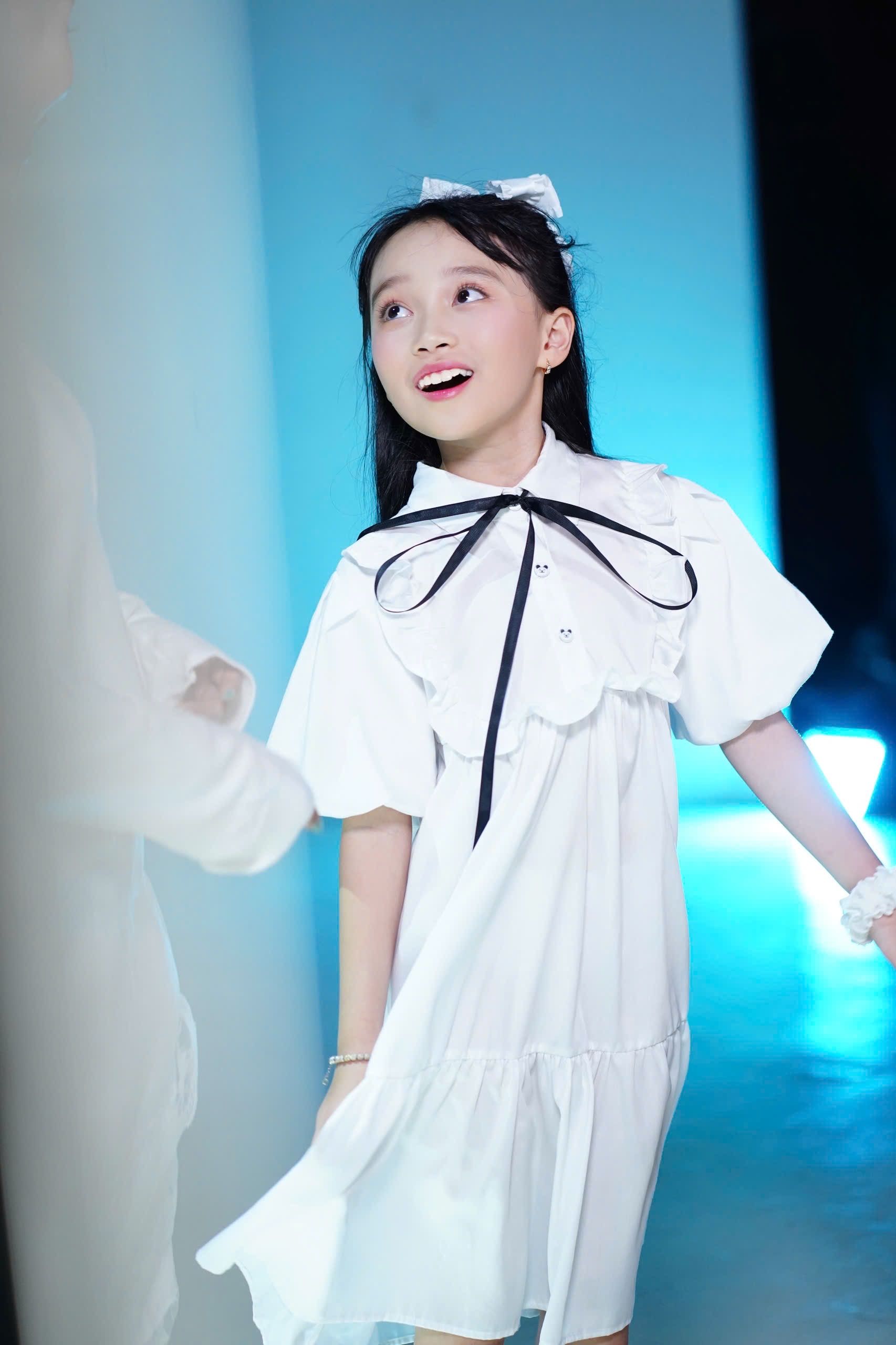 Young Girl in White Dress Smiling Indoors · Free Stock Photo