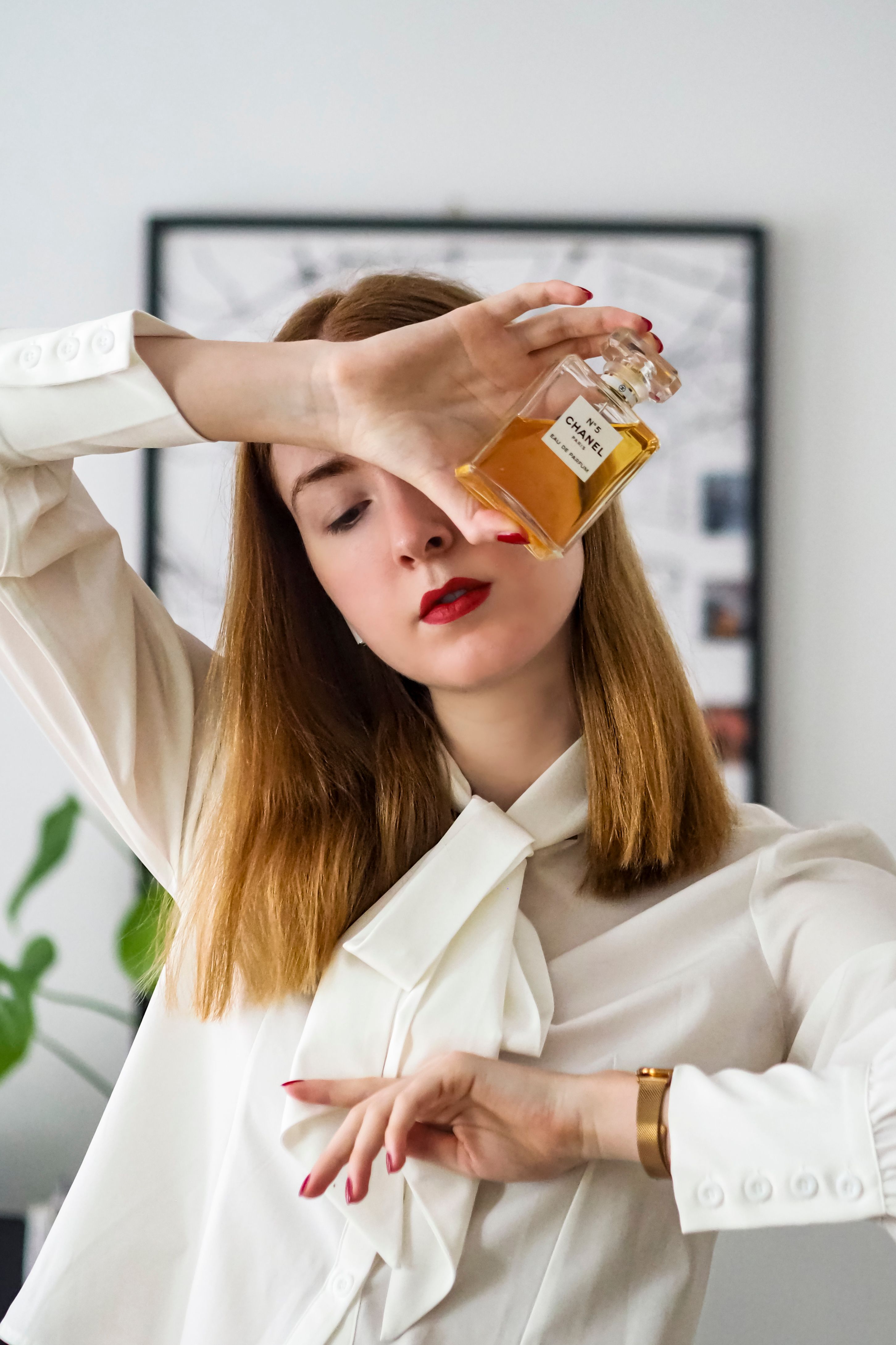 Uma mulher estilosa com perfume Chanel, exibindo elegância e moda em Paris.