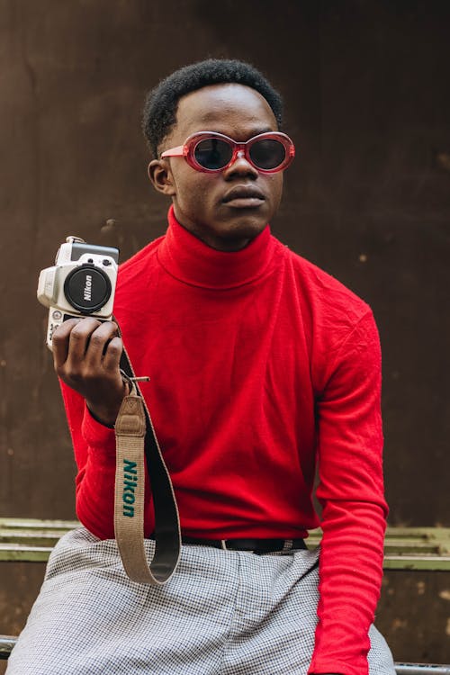 Man in Red Turtleneck Sweater Holding Dslr Camera