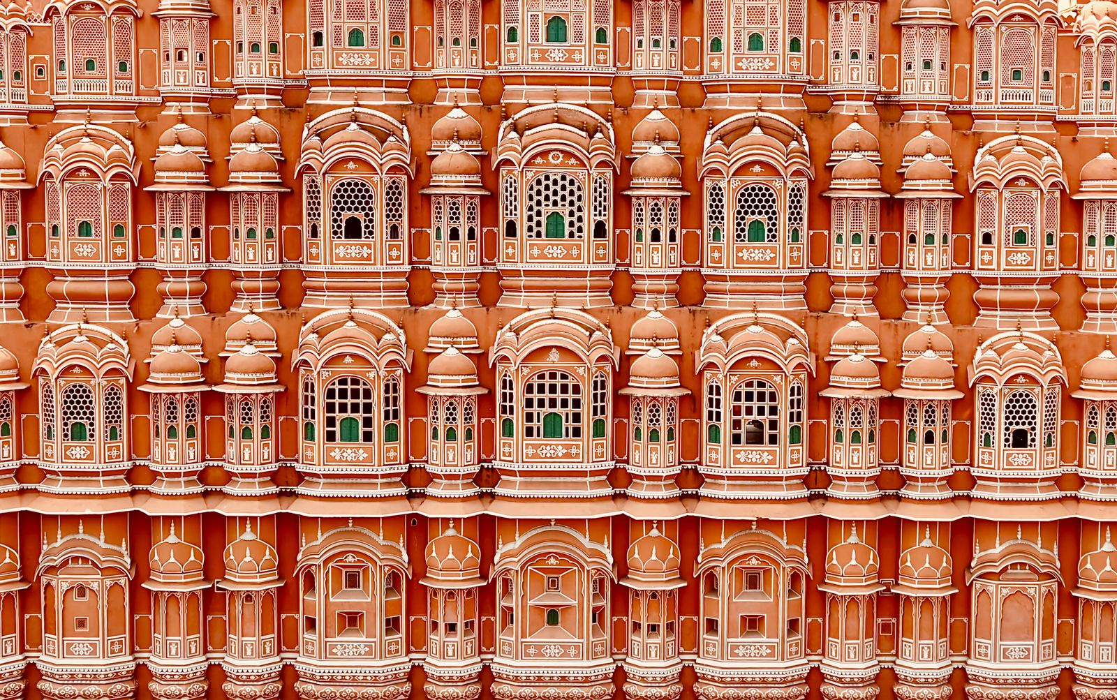 Iconic Hawa Mahal facade in Jaipur, India, showcasing intricate windows and traditional architecture.