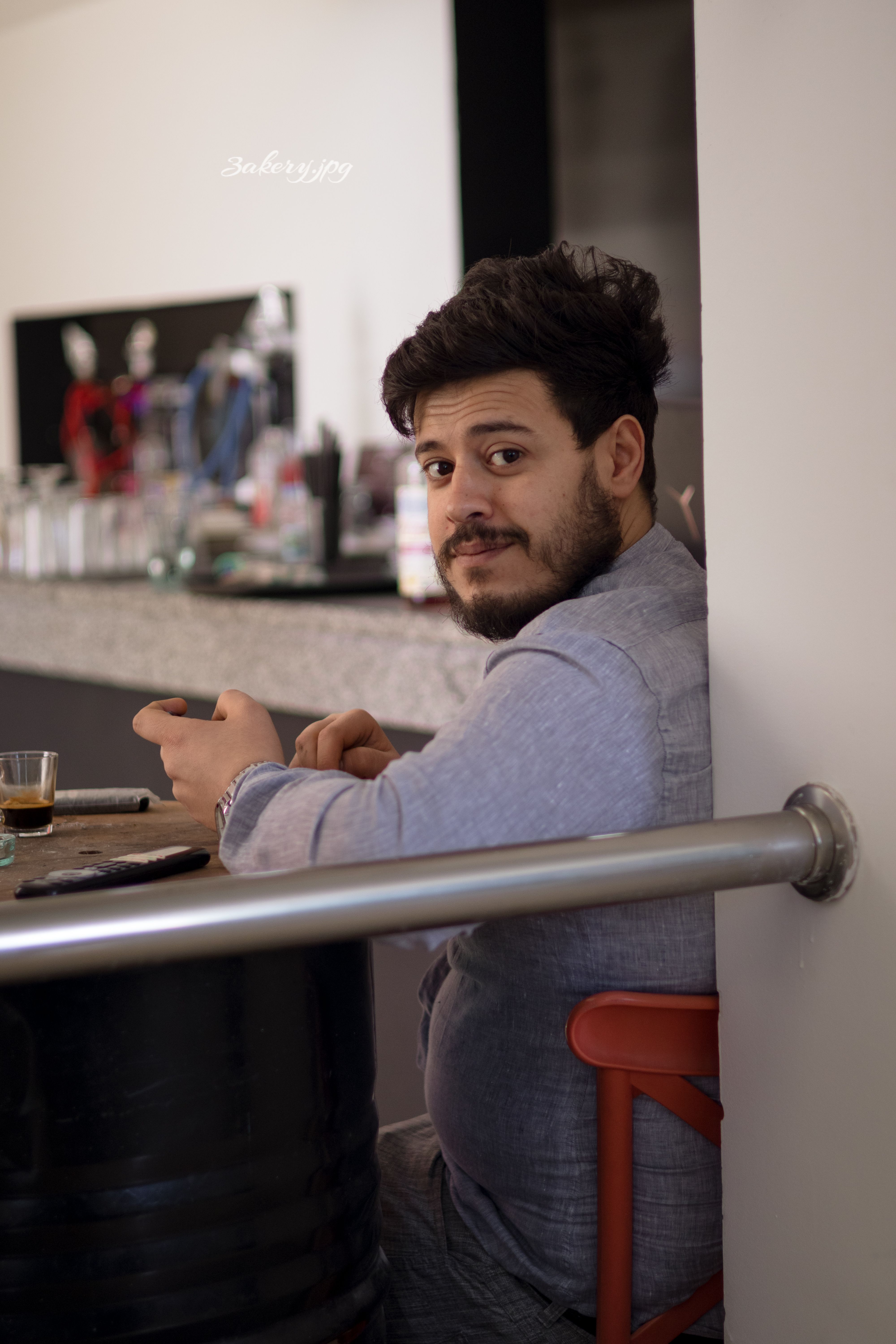 Casual scene of a man enjoying coffee at a home table, looking back.