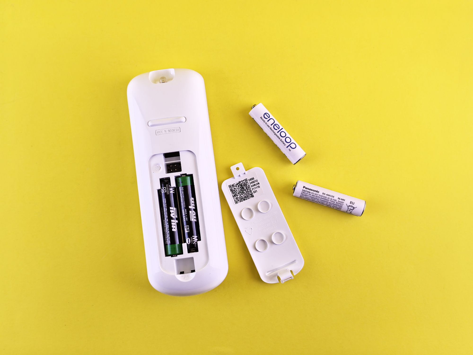 Remote Control with Batteries on Yellow Background · Free Stock Photo