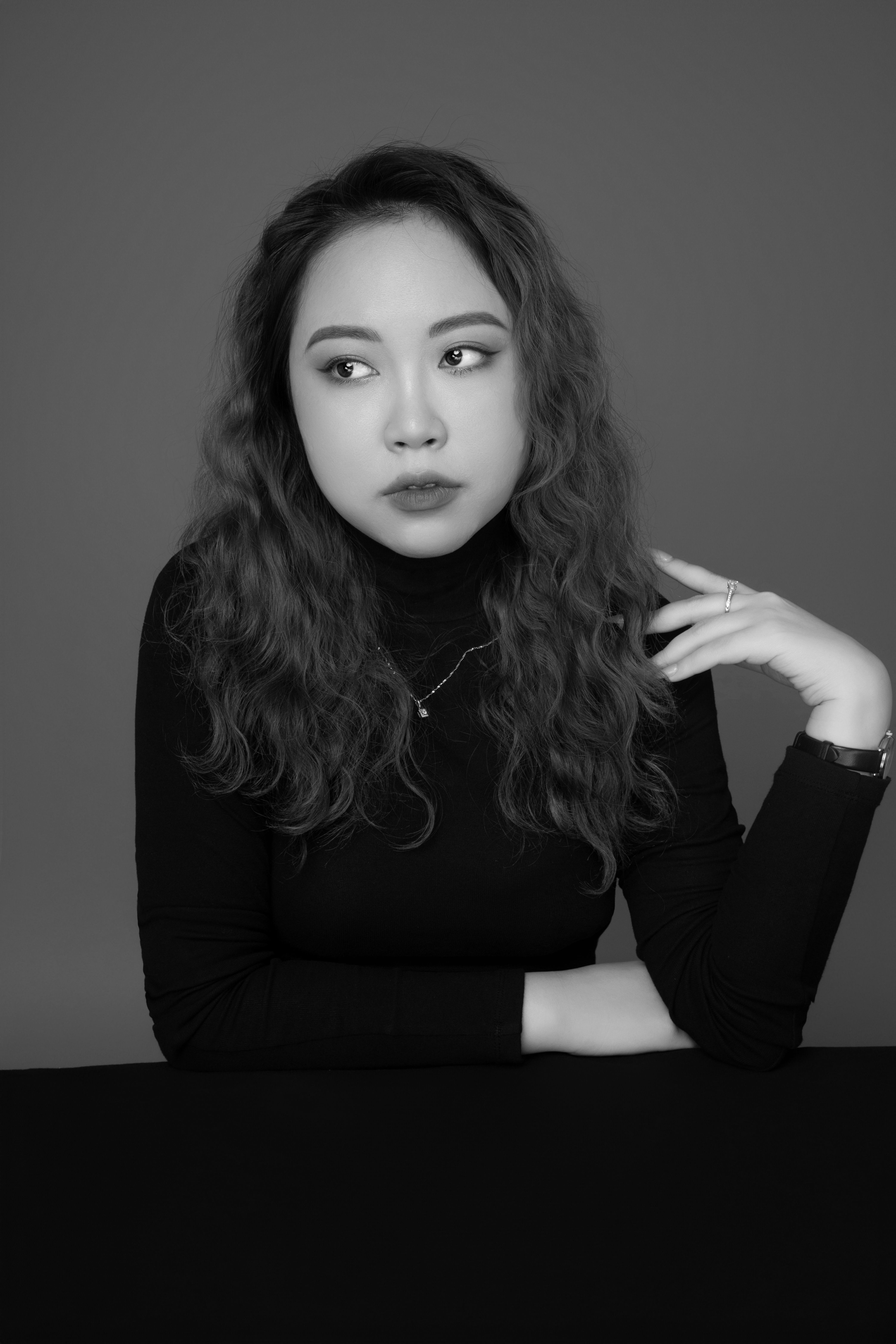 Elegant black and white portrait of a thoughtful woman with long hair in Ho Chi Minh City.