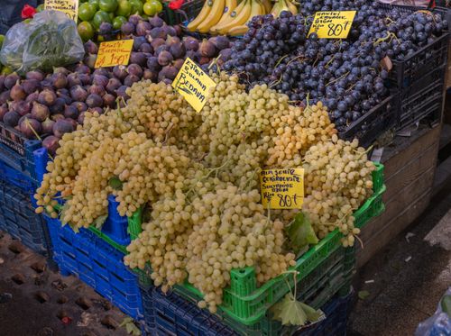 Free Fresh grapes and various fruits displayed at a bustling market in İzmir, Turkey. Stock Photo