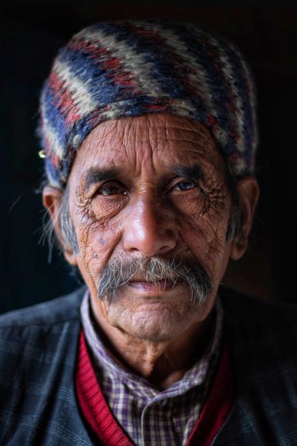 Close-up portrait of an elderly man with a traditional hat showcasing rich facial expressions.