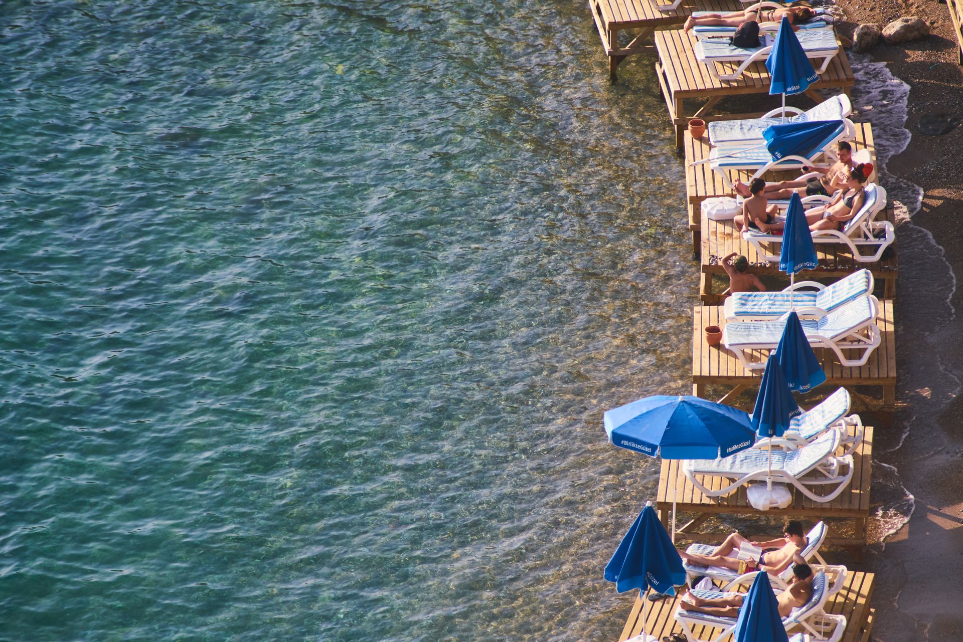 Relaxing on wooden platforms by the beach in Antalya, Turkey.