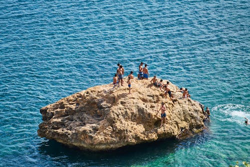Free 人们聚集在海中的岩层上 Stock Photo