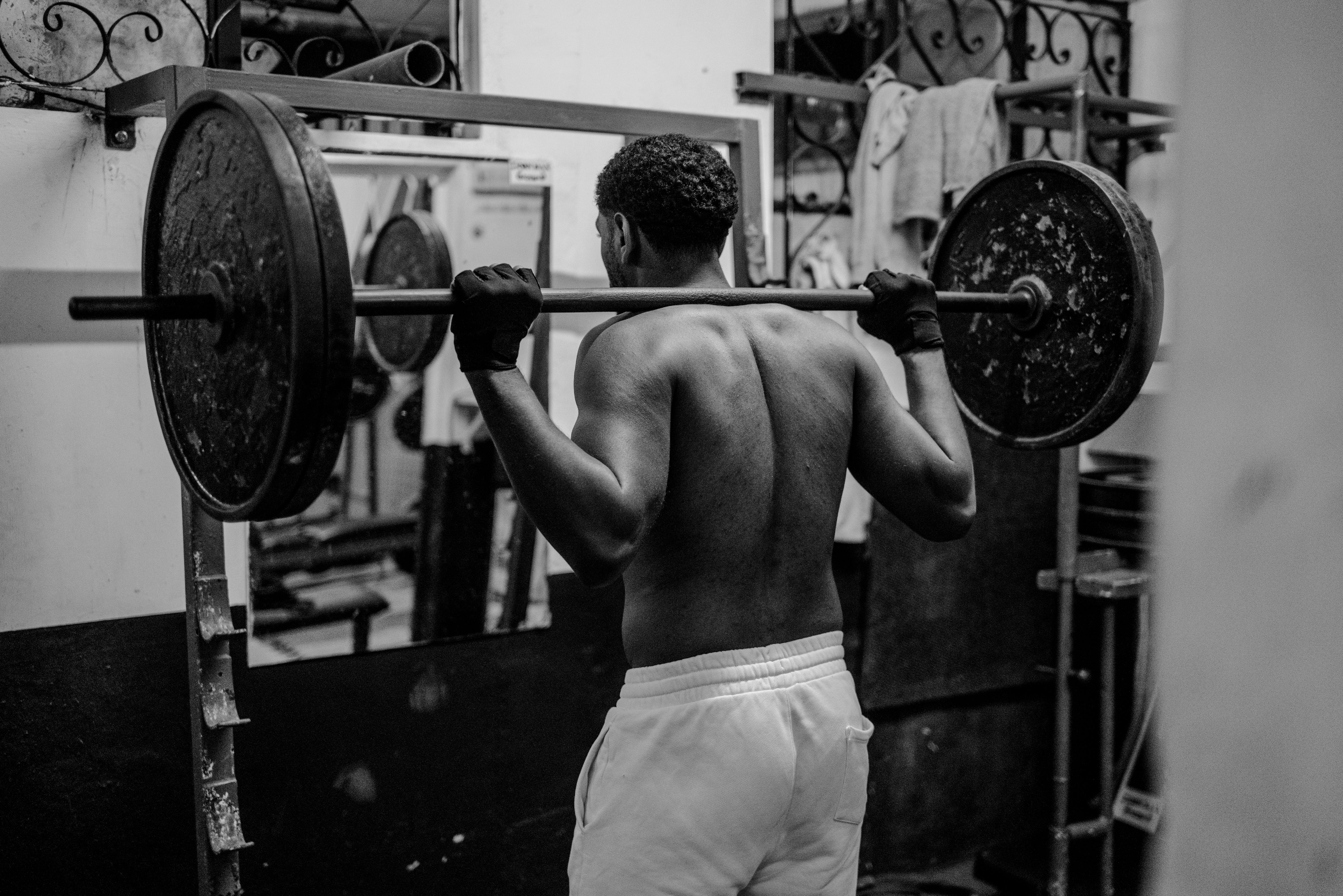 A determined man lifting weights in a gym, showcasing strength and fitness focus.