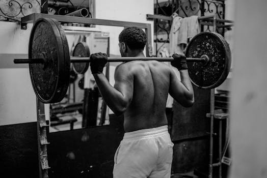 A determined man lifting weights in a gym, showcasing strength and fitness focus.
