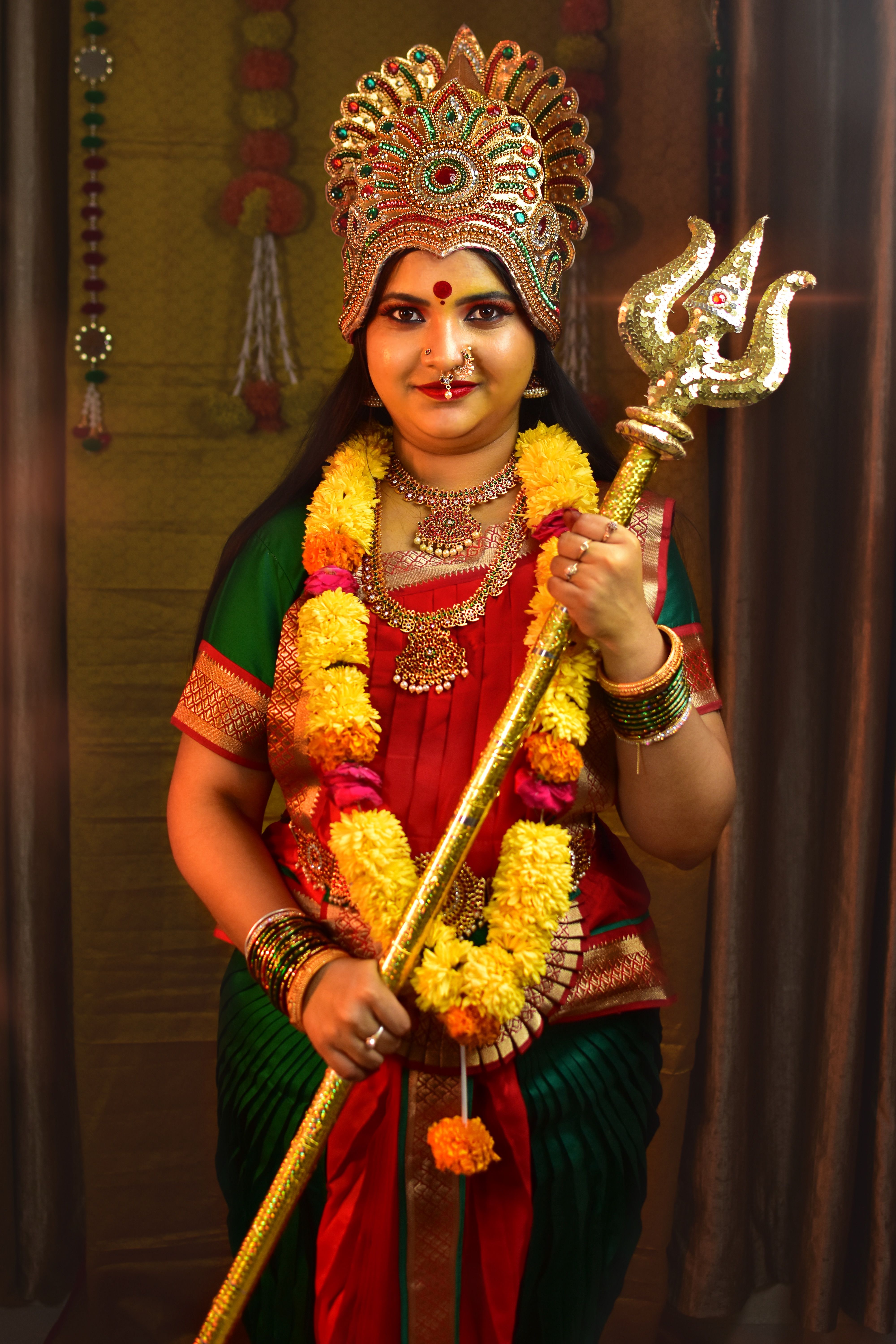 A woman dressed as Goddess Durga holding a trident, showcasing Indian cultural attire and traditions.