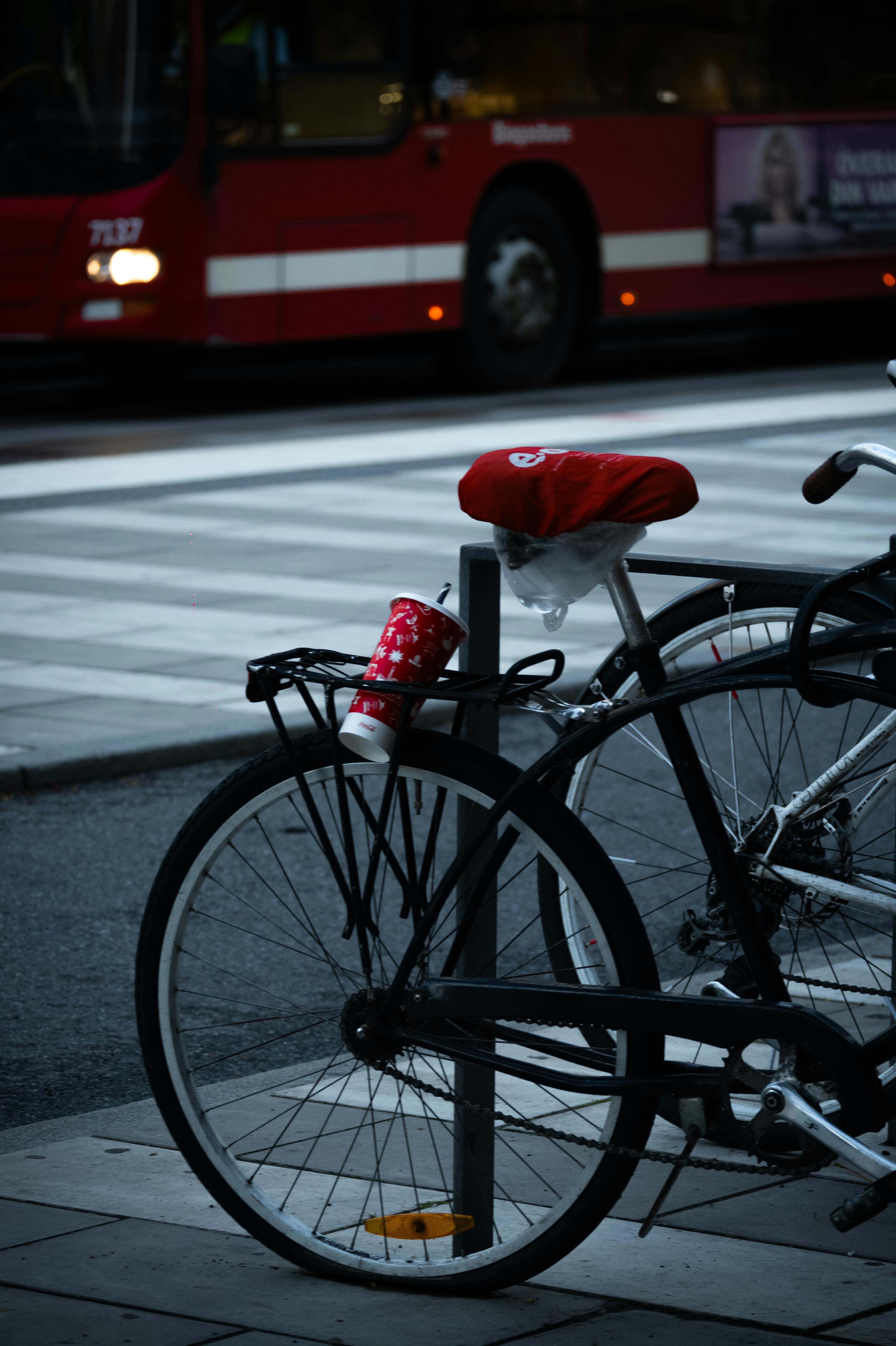 Free Bicycle parked on a street in Stockholm with a red city bus in the background. Stock Photo
