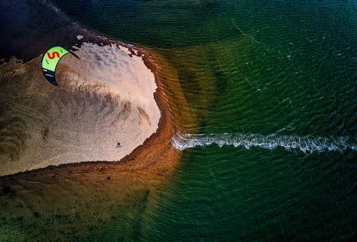 Dynamic aerial shot capturing kite surfing on vibrant waters at Exmouth, England.